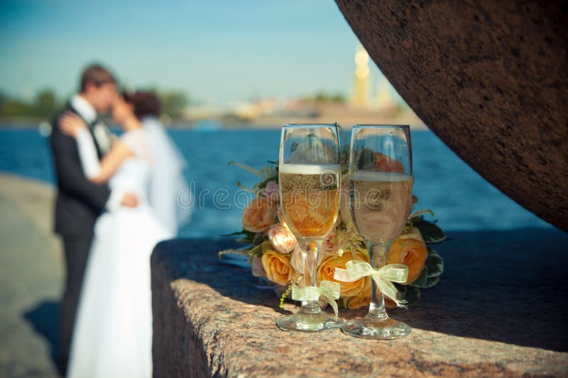 Zwei Gläser mit Champagner und einem Blumenstrauß von Rosen auf einem backgroun stockfotografie Zwei Gläser mit Champagner und einem Blumenstrauß von Rosen auf einem backgroun stockfotografie