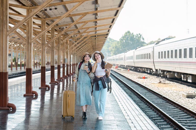 Zwei glückliche Fahrgäste auf Bahnsteig mit Gepäck an einem sonnigen Tag stockfotos
