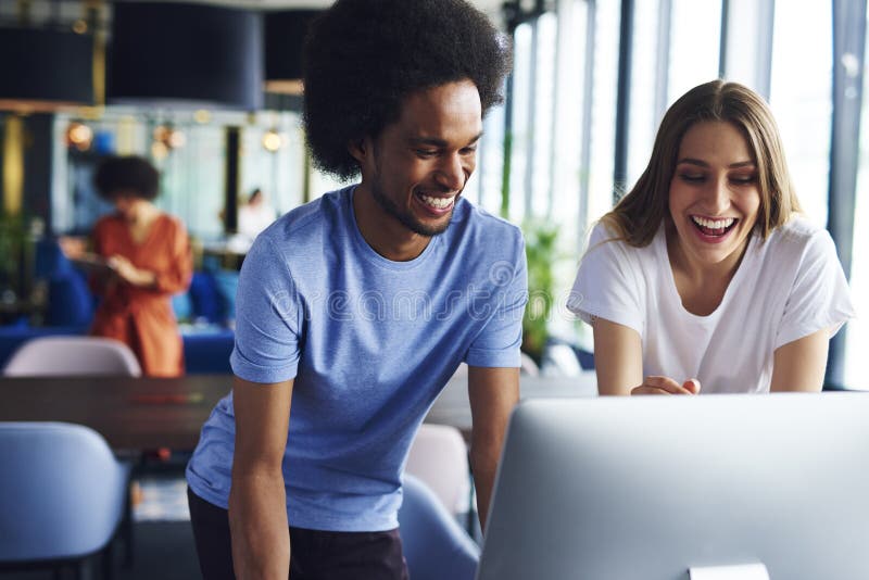 Zwei glückliche Mitarbeiter, die an Computer arbeiten lizenzfreies stockbild Zwei glückliche Mitarbeiter, die an Computer arbeiten lizenzfreies stockbild