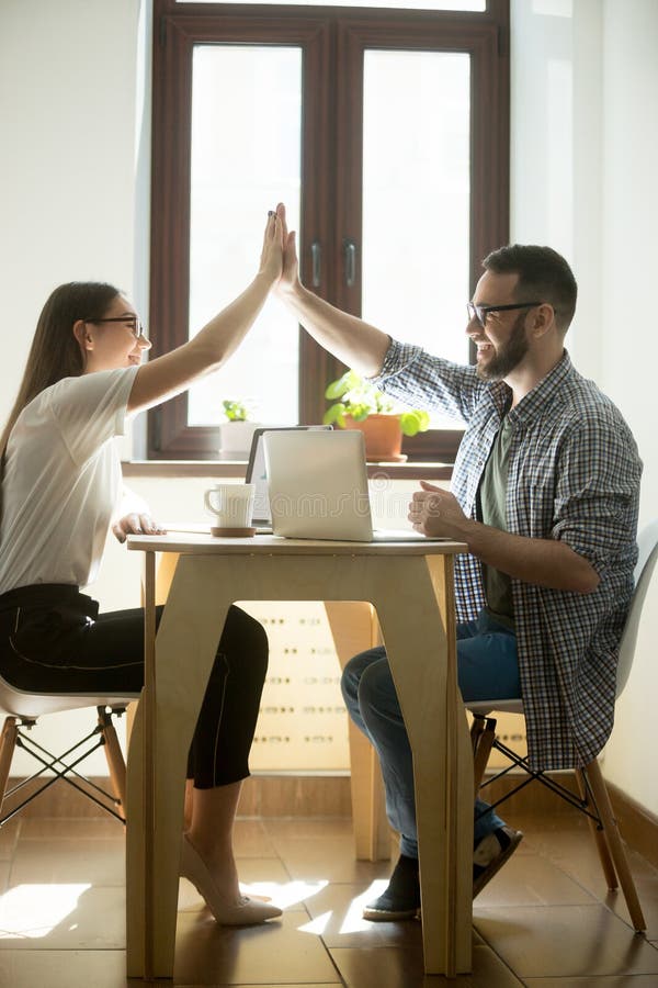 Zwei glückliche Mitarbeiter, die hohe fives auf Geschäftstreffen geben lizenzfreies stockfoto Zwei glückliche Mitarbeiter, die hohe fives auf Geschäftstreffen geben lizenzfreies stockfoto