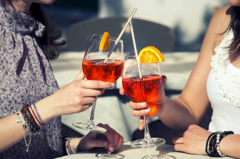 Zwei glückliche Mädchen, während sie ein Cocktail trinken stockfoto Zwei glückliche Mädchen, während sie ein Cocktail trinken stockfoto