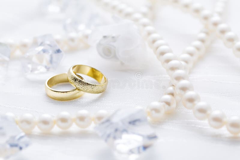 Zwei goldene Ringe mit Perlenkette und weißem Hintergrund lizenzfreie stockfotos Zwei goldene Ringe mit Perlenkette und weißem Hintergrund lizenzfreie stockfotos