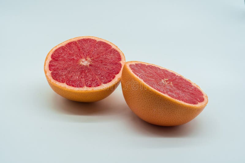 Zwei halbe saftige und köstliche Grapefruits auf weißem Hintergrund lizenzfreie stockfotos