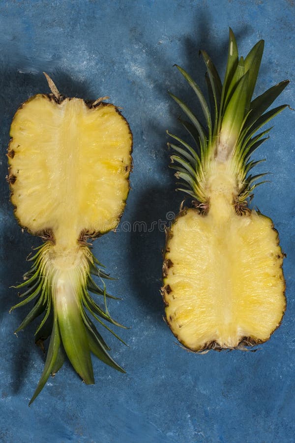 Zwei halbsaftige Ananas auf blauem Hintergrund Minimales Obstkonzept Oberansicht stockbild