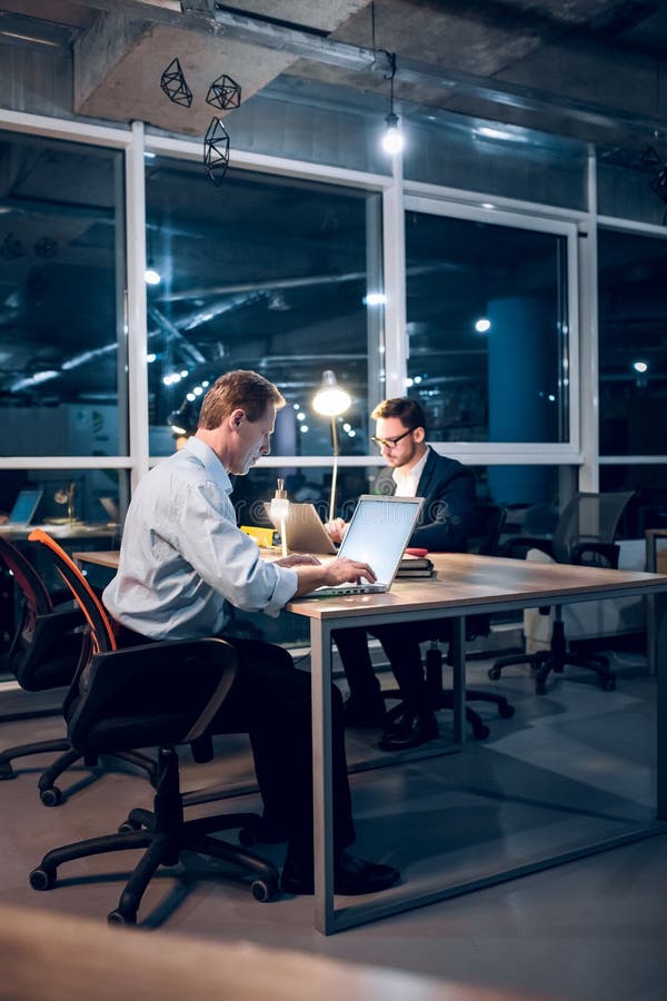 Zwei Herren, die oben spät in der Bürofunktion bleiben lizenzfreie stockfotografie