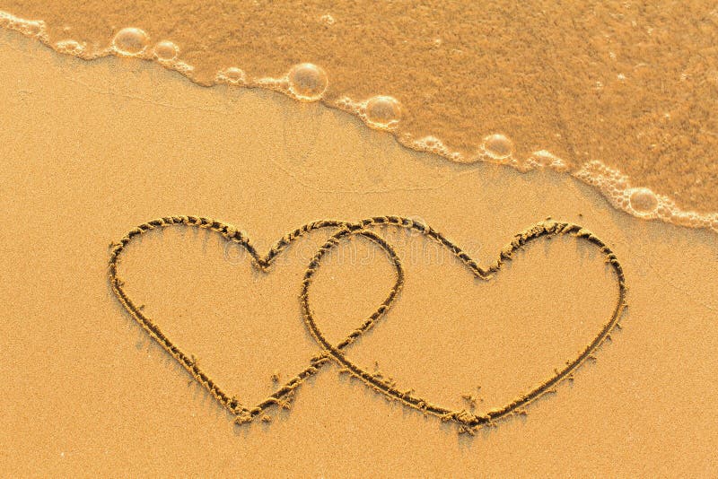 Zwei Herzen gezeichnet in den Meersand mit der weichen Welle Liebe stockbilder Zwei Herzen gezeichnet in den Meersand mit der weichen Welle Liebe stockbilder