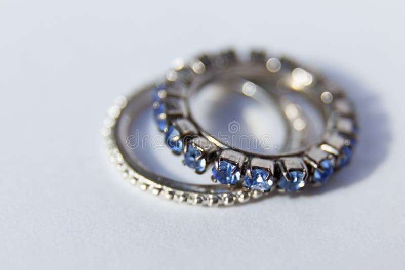 Zwei Hochzeitsringe, einer mit blauen Diamanten lizenzfreie stockbilder Zwei Hochzeitsringe, einer mit blauen Diamanten lizenzfreie stockbilder