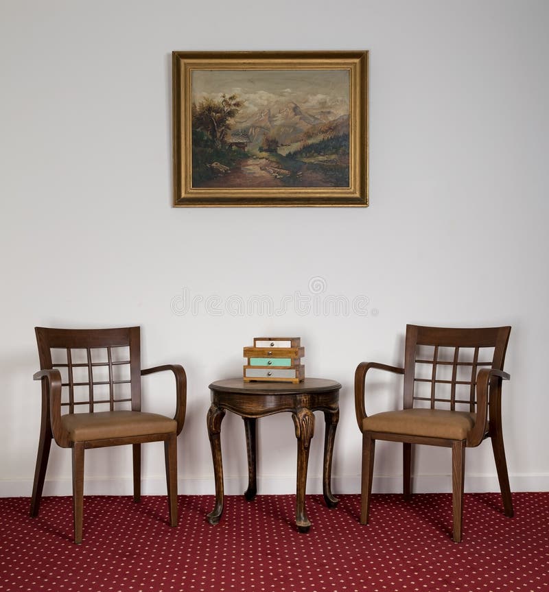 Zwei hölzerne Lehnsessel, kleiner runder Couchtisch und gestaltete Malerei lizenzfreies stockbild Zwei hölzerne Lehnsessel, kleiner runder Couchtisch und gestaltete Malerei lizenzfreies stockbild