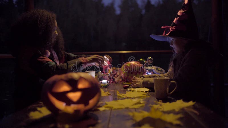 Zwei jugendlich Mädchen, die Süßes sonst gibt's Saures candys nach an Halloween-Nacht teilen