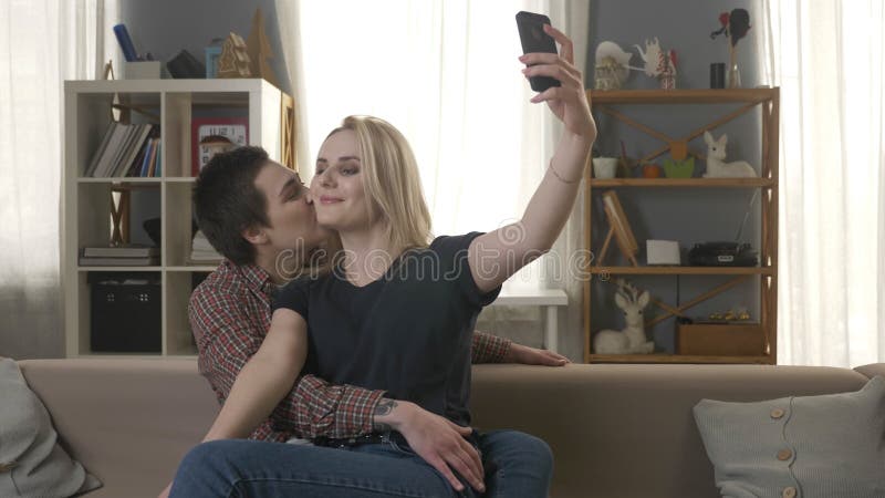 Zwei jung, schöne Mädchen sitzen auf der Couch, küssen und machen selfies, Lesben, LGBT, Blondine, Brunette 60 fps