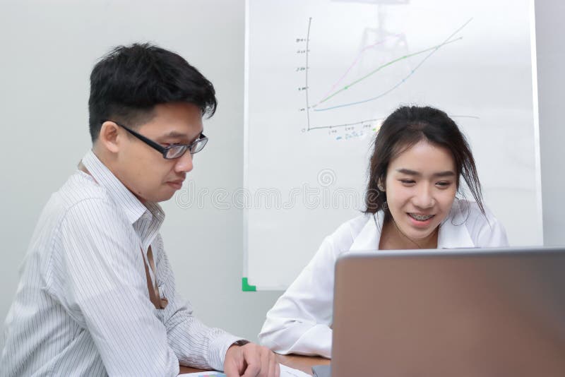 Zwei junge asiatische Geschäftsleute, die mit Laptop im modernen Büro zusammenarbeiten Teamarbeits-Geschäftskonzept Selektiver Fo lizenzfreie stockbilder Zwei junge asiatische Geschäftsleute, die mit Laptop im modernen Büro zusammenarbeiten Teamarbeits-Geschäftskonzept Selektiver Fo lizenzfreie stockbilder