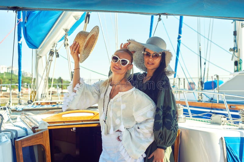 Zwei junge attraktive Frauen stehen auf einer Yacht an einem sonnigen Tag still stockbild Zwei junge attraktive Frauen stehen auf einer Yacht an einem sonnigen Tag still stockbild