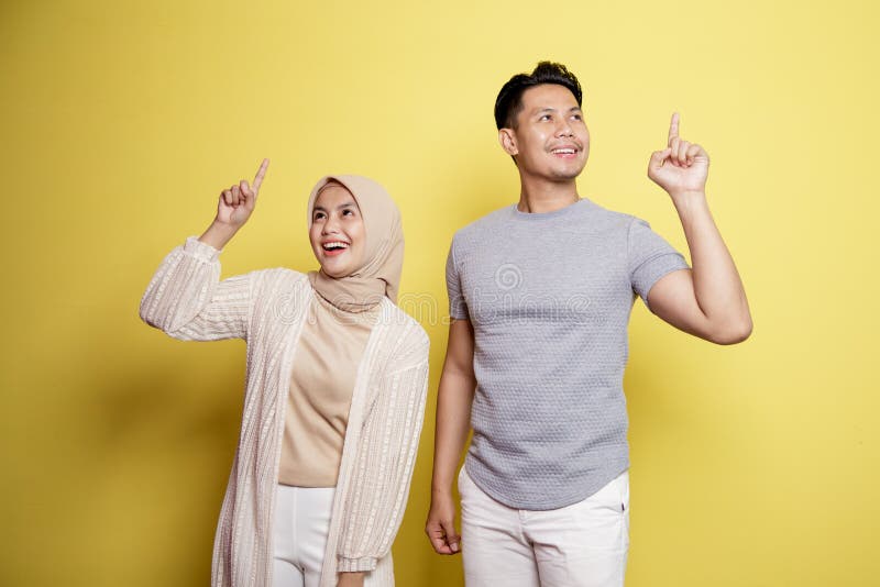 Zwei junge eine Frau hijab und ein Mann mit einem Ausdruck glücklich haben etwas gute Idee zusammen stockfotos
