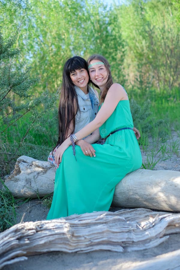 Zwei junge Frauen, die auf dem Gras hat gute Zeit sitzen lizenzfreies stockfoto Zwei junge Frauen, die auf dem Gras hat gute Zeit sitzen lizenzfreies stockfoto