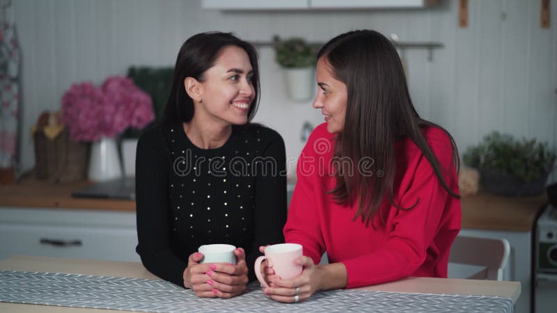 Zwei junge Freunde trinken abends Tee in der Küche, reden und Spaß haben