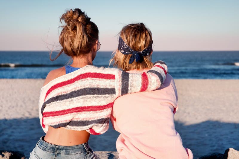 Zwei Junge Mädchen Beste Freunde Die Zusammen Auf Dem Strand An S Sitzen Stockbild Bild Von 