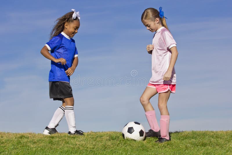 Zwei junge Mädchen, die Fußball spielen stockbild Zwei junge Mädchen, die Fußball spielen stockbild