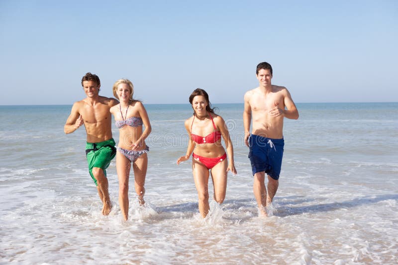 Zwei junge Paare am Strandfeiertag lizenzfreies stockbild Zwei junge Paare am Strandfeiertag lizenzfreies stockbild