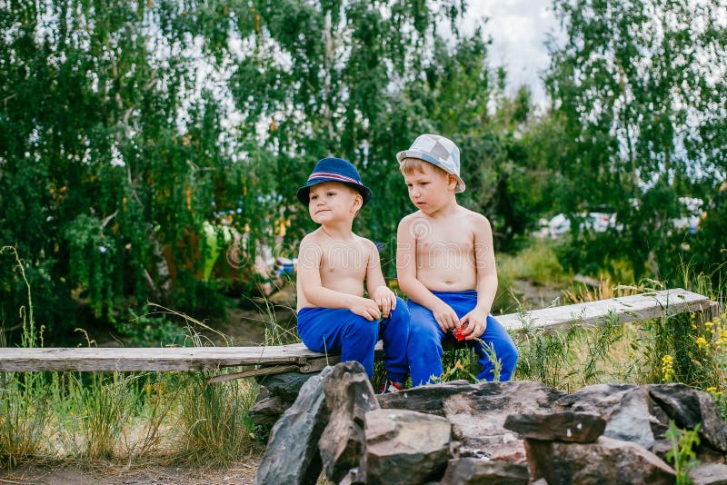 Zwei Jungen in den blauen Hosen und in den Hüten stockbild Zwei Jungen in den blauen Hosen und in den Hüten stockbild