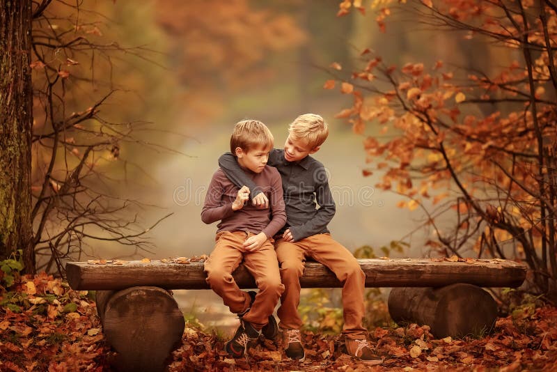 Zwei Jungen, Die Auf Einer Bank Durch Den Teich Sitzen Stockfoto Bild