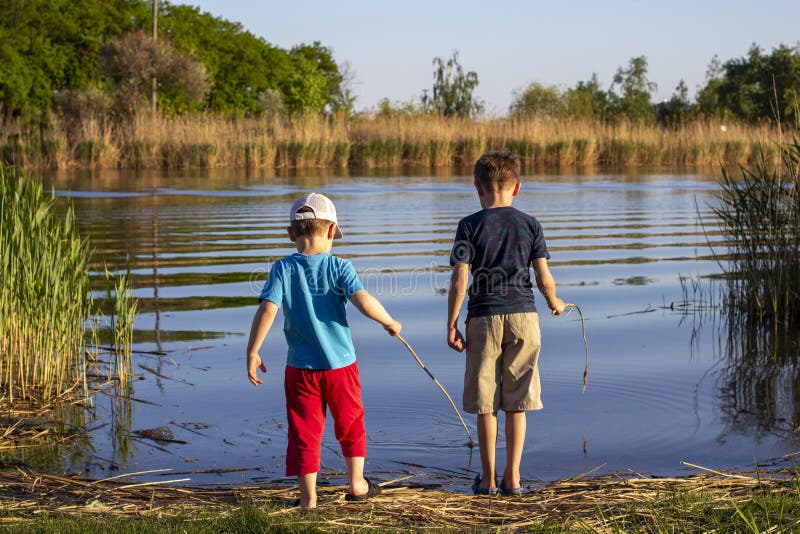 Zwei Jungs stehen am Fluss. das Konzept der Freundschaft und Brüderlichkeit. Sommer lizenzfreie stockbilder