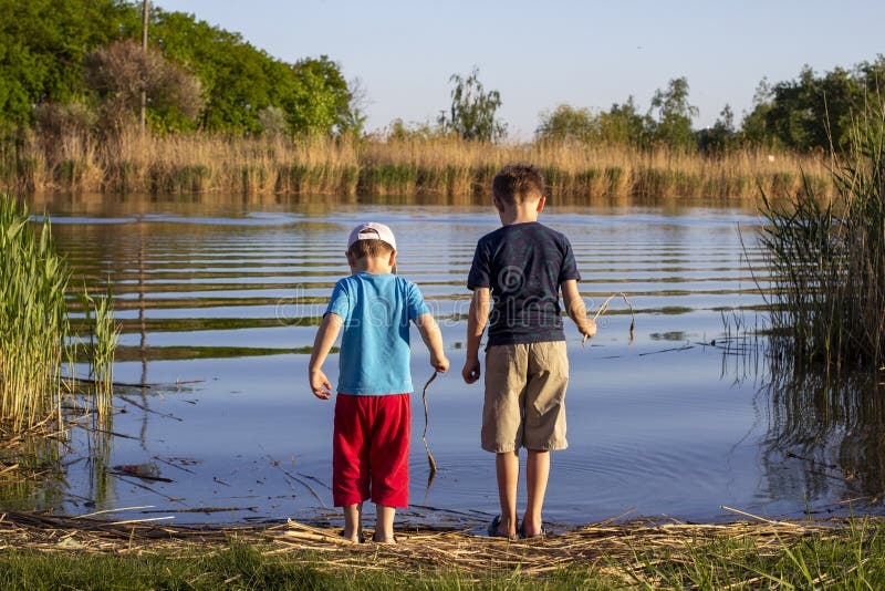 Zwei Jungs stehen am Fluss. das Konzept der Freundschaft und Brüderlichkeit. Sommer lizenzfreies stockfoto