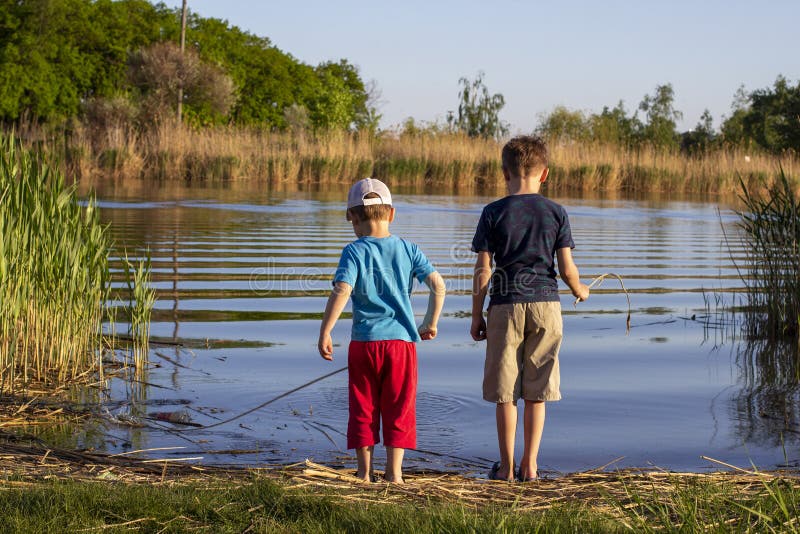 Zwei Jungs stehen am Fluss. das Konzept der Freundschaft und Brüderlichkeit. Sommer lizenzfreie stockfotos