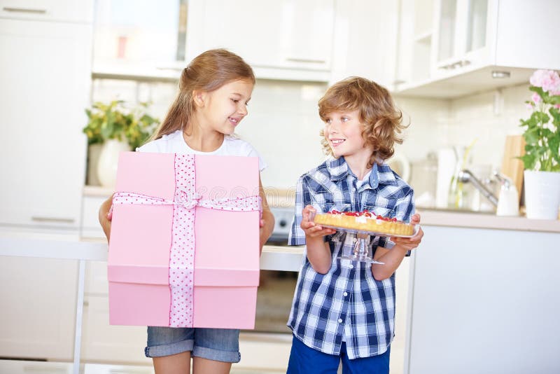Zwei Kinder am Geburtstag mit Geschenk und Kuchen lizenzfreie stockfotos Zwei Kinder am Geburtstag mit Geschenk und Kuchen lizenzfreie stockfotos