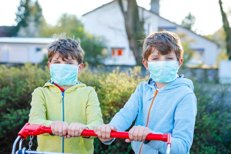Zwei Kinder Jungen in ärztlicher Maske als Schutz vor einer pandemischen Koronavirus-Krankheit Kinder mit Schutzausrüstung lizenzfreies stockbild Zwei Kinder Jungen in ärztlicher Maske als Schutz vor einer pandemischen Koronavirus-Krankheit Kinder mit Schutzausrüstung lizenzfreies stockbild