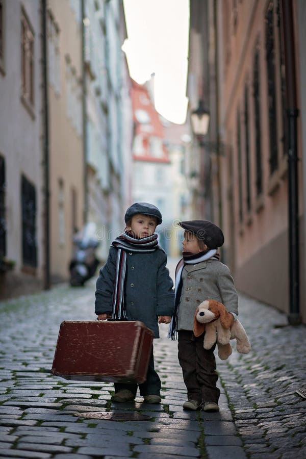 Zwei Kinder, Jungenbrüder, tragender Koffer und Hundespielzeug, Reise in der Stadt allein lizenzfreies stockfoto Zwei Kinder, Jungenbrüder, tragender Koffer und Hundespielzeug, Reise in der Stadt allein lizenzfreies stockfoto