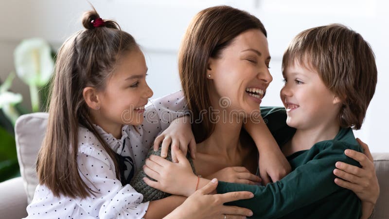 Zwei Kinder umarmen, die glückliche Mutter zu decken, die Liebe zeigt lizenzfreie stockbilder