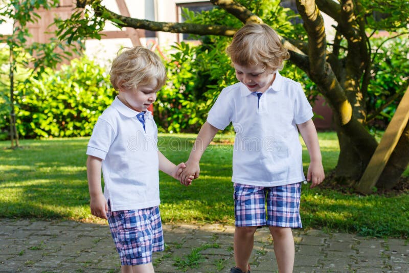 Zwei kleine Geschwisterjungen, die Spaß draußen im Familienblick haben lizenzfreies stockfoto Zwei kleine Geschwisterjungen, die Spaß draußen im Familienblick haben lizenzfreies stockfoto