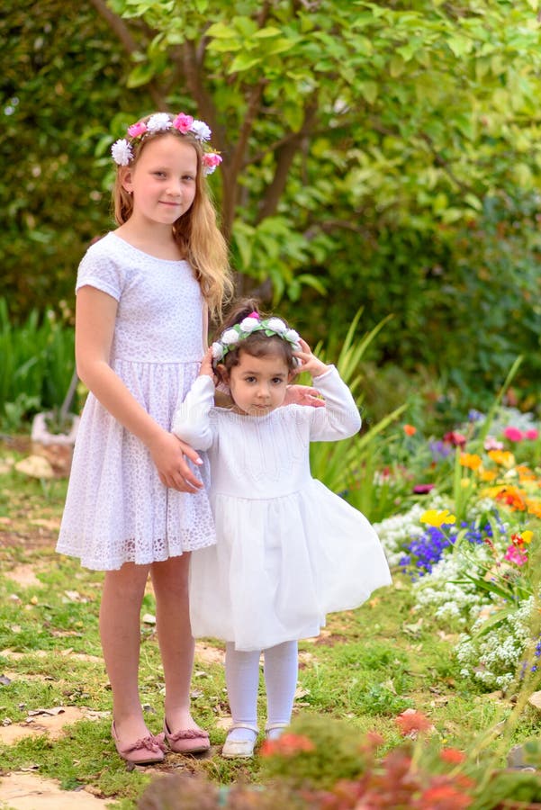 Zwei kleine M?dchen in den wei?en Kleidern und im Blumenkranz, der Spa? ein Sommergarten hat stockbilder Zwei kleine M?dchen in den wei?en Kleidern und im Blumenkranz, der Spa? ein Sommergarten hat stockbilder
