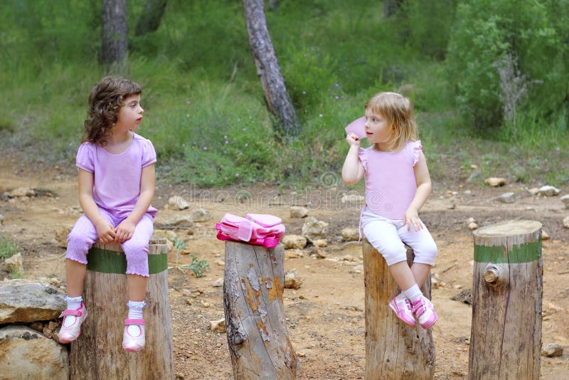 Zwei Kleine Mädchen Sitzen Auf Waldpark-Baumkabeln Stockbild - Bild von
