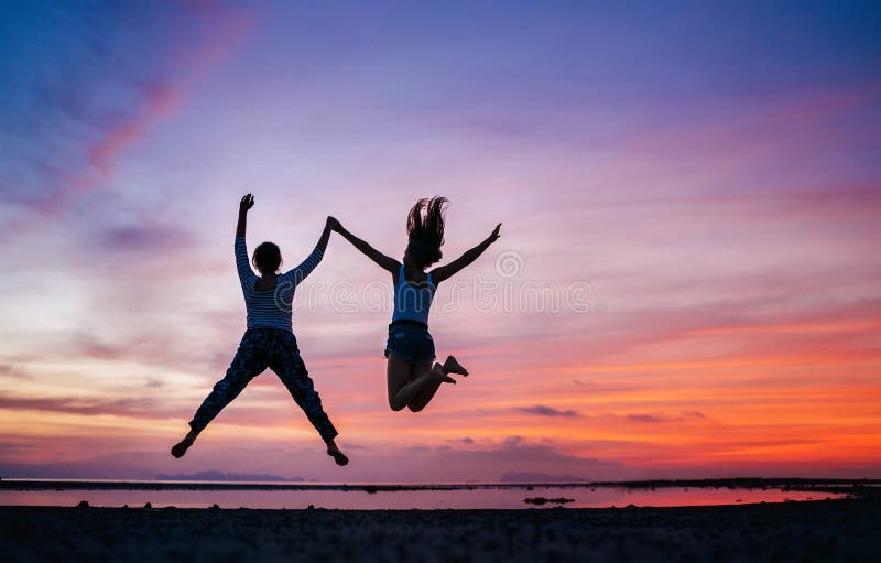 Zwei laufend und springende Freundinnen auf dem Sonnenuntergangseestrand Hand in Hand Konzeptbild stockbilder Zwei laufend und springende Freundinnen auf dem Sonnenuntergangseestrand Hand in Hand Konzeptbild stockbilder