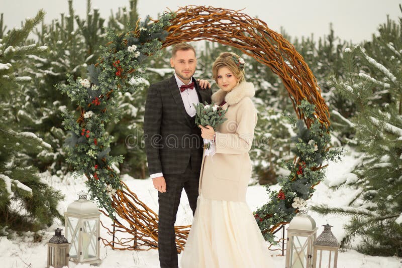 Zwei Liebhaber, ein Mann und eine Frau, eine Hochzeit im Winter Braut- und Bräutigamliebe gegen den Hintergrund des Dekors und de lizenzfreies stockbild Zwei Liebhaber, ein Mann und eine Frau, eine Hochzeit im Winter Braut- und Bräutigamliebe gegen den Hintergrund des Dekors und de lizenzfreies stockbild