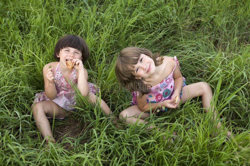 Zwei Mädchen, Die Im Gras Sitzen Stockfoto - Bild von sonne, freund