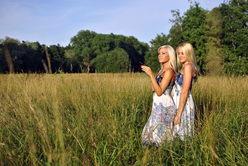 Zwei Mädchen Im Gras Nahe Dem Wald Stockfoto - Bild von kaukasisch