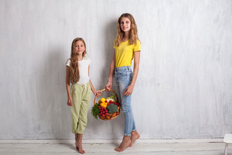 Zwei Mädchen mit einem Korb der gesunder Ernährung der frischen Frucht stockbild Zwei Mädchen mit einem Korb der gesunder Ernährung der frischen Frucht stockbild