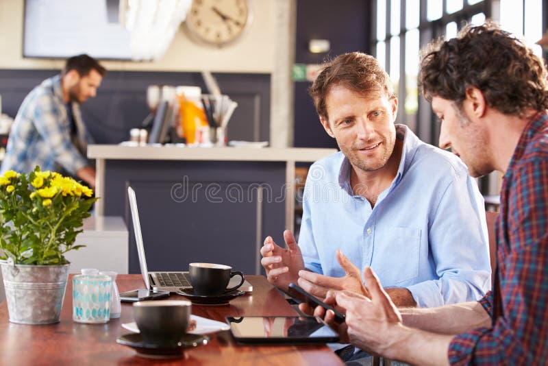 Zwei Männer, die an einer Kaffeestube sich treffen