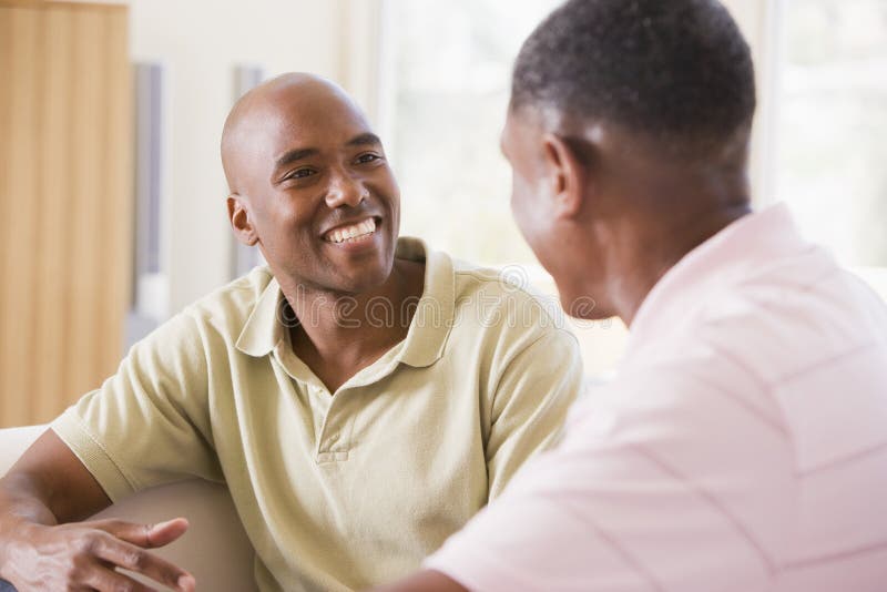 Zwei Männer im Wohnzimmer sprechend und lächelnd stockfoto Zwei Männer im Wohnzimmer sprechend und lächelnd stockfoto