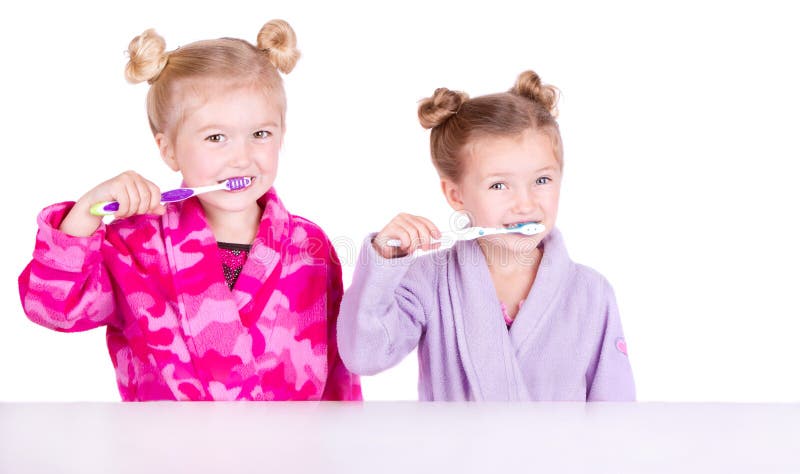 Zwei nette Mädchen, die Zähne putzen stockbild