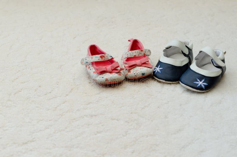 Zwei Paare des Babys erstes beschuht ein Blau mit Blume auf der T lizenzfreie stockfotografie Zwei Paare des Babys erstes beschuht ein Blau mit Blume auf der T lizenzfreie stockfotografie