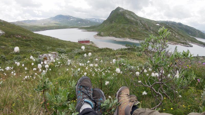 Zwei Reisende sitzen auf dem Hügel über einem norwegischen Fjord
