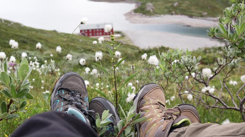 Zwei Reisende sitzen auf dem Hügel über einem norwegischen Fjord