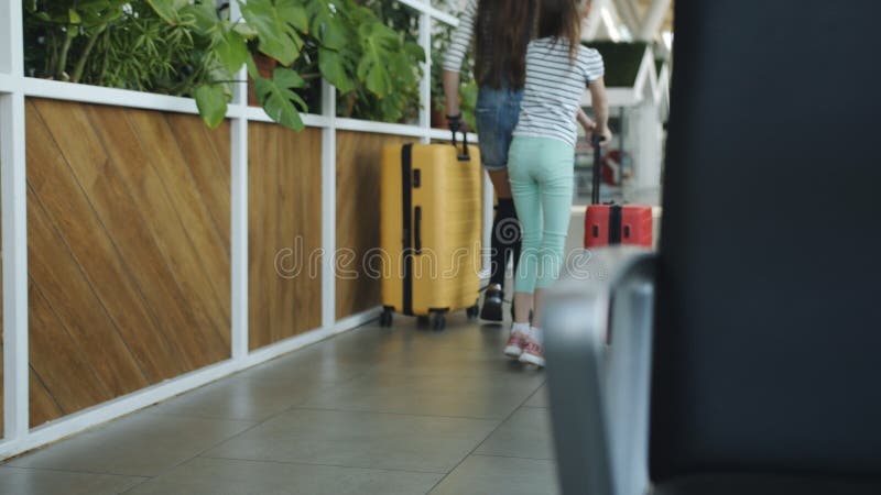 Zwei Schwestern mit farbenfrohen Taschen fahren zum Flughafen
