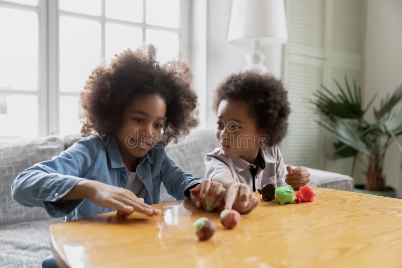 Zwei schöne schwarze Kinder, die zu Hause kreative Handwerkstätigkeit üben stockfotografie