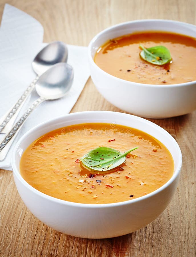 Two bowls of squash soup on wooden table. Two bowls of squash soup on wooden table