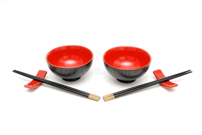 Two sets of chopsticks on stands and the red and black Japanese bowls isolated. Two sets of chopsticks on stands and the red and black Japanese bowls isolated