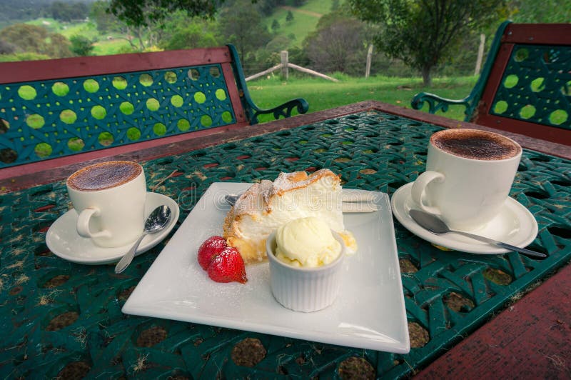 Zwei Tasse Kaffees mit Zitronenmeringekuchen, -erdbeere und -schaufel der Eiscreme stockfotos Zwei Tasse Kaffees mit Zitronenmeringekuchen, -erdbeere und -schaufel der Eiscreme stockfotos